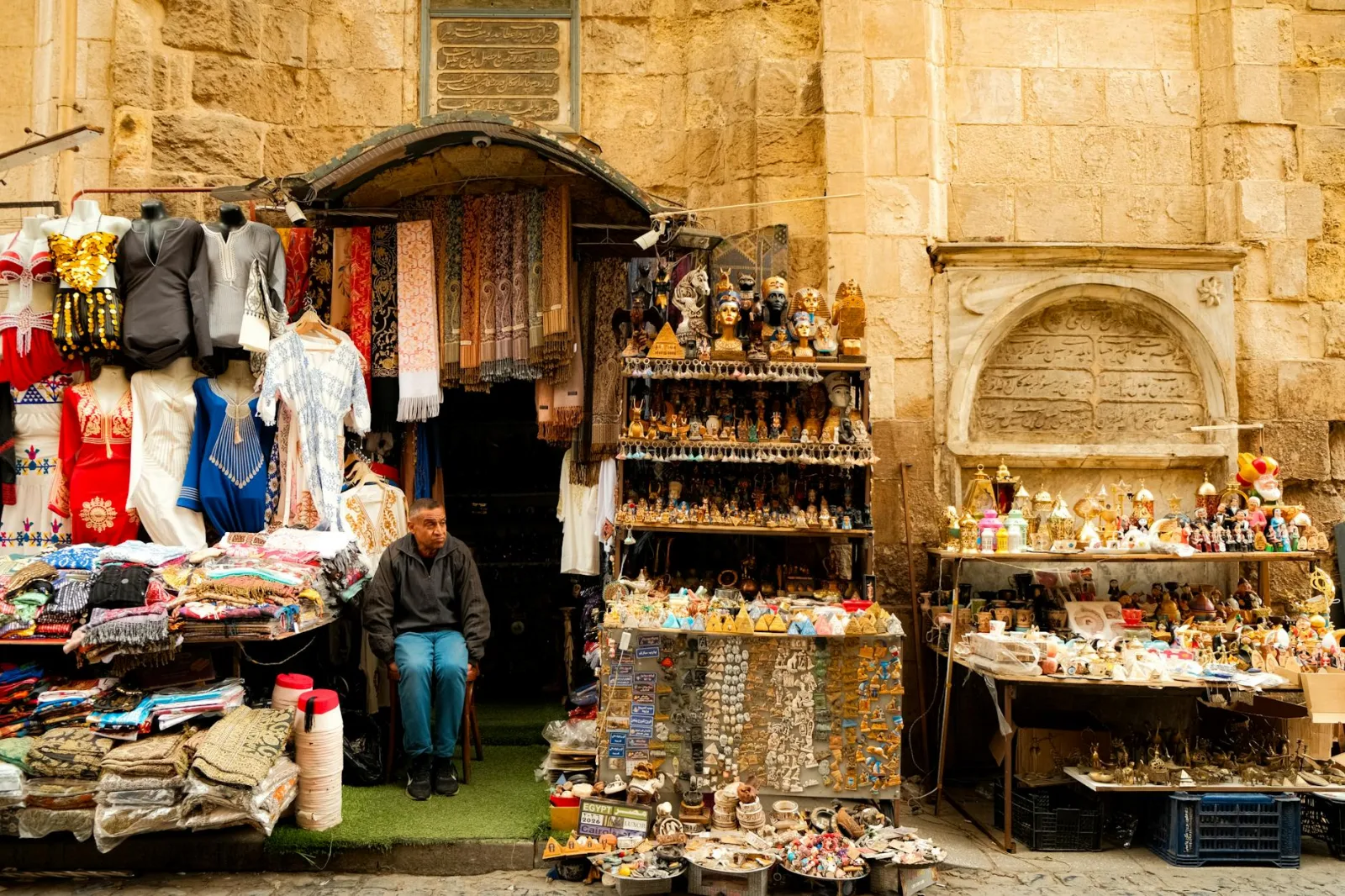 Colorful outdoor market stall with traditional souvenirs and clothing. Captures local culture and commerce.