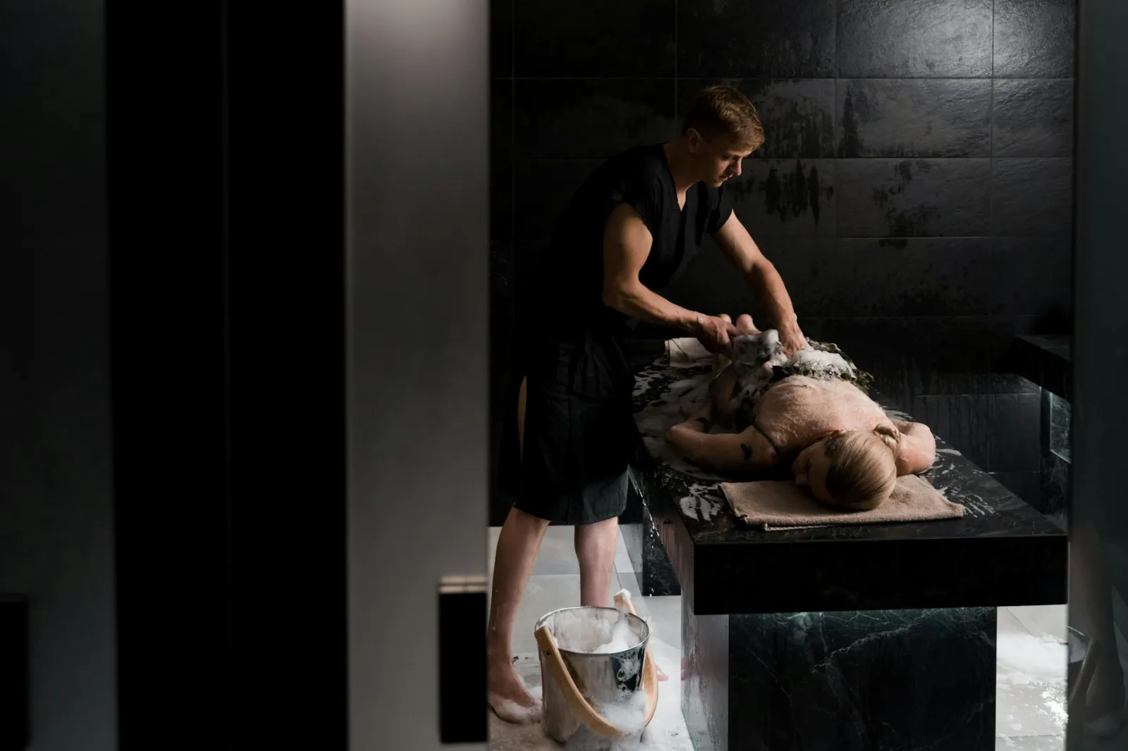 A professional giving a soothing soap massage in a relaxing spa environment, promoting relaxation and wellness.