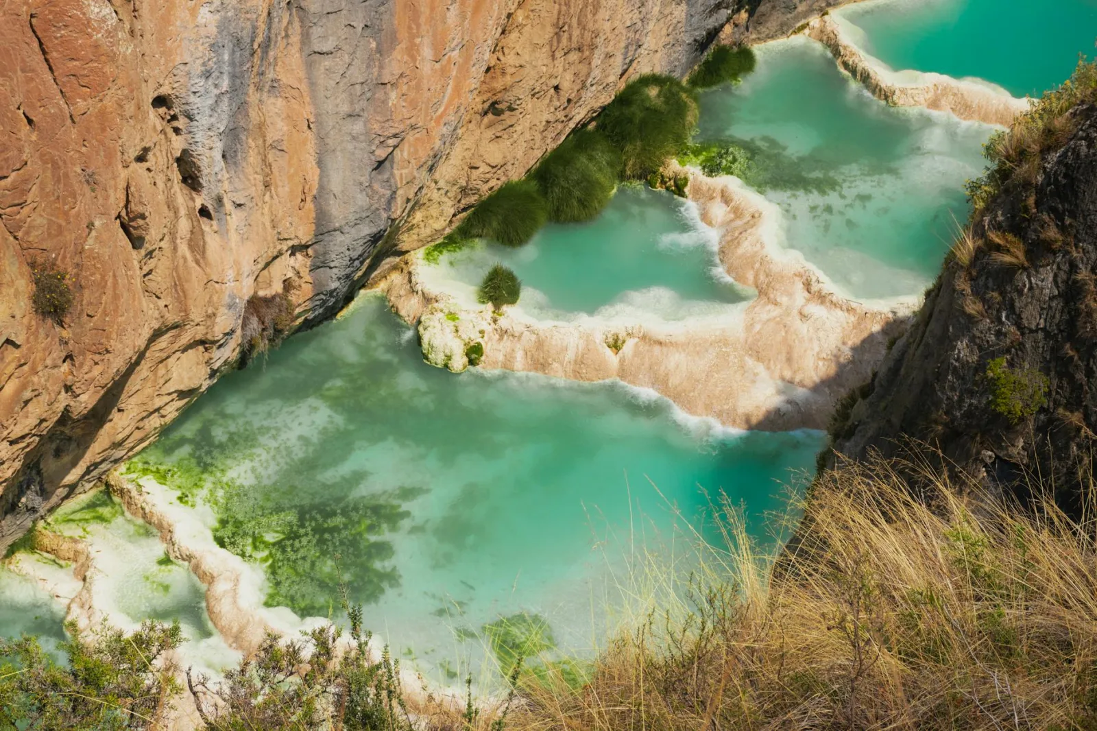 A stunning view of natural lagoons surrounded by rocky cliffs in Ayacucho, Peru.