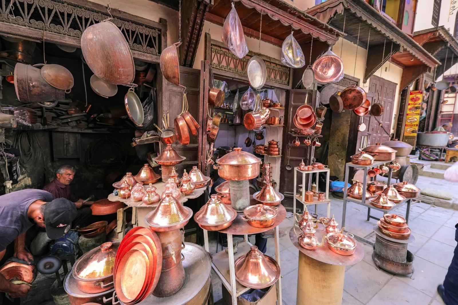 Vibrant stall showcasing traditional copper cookware in a bustling marketplace.