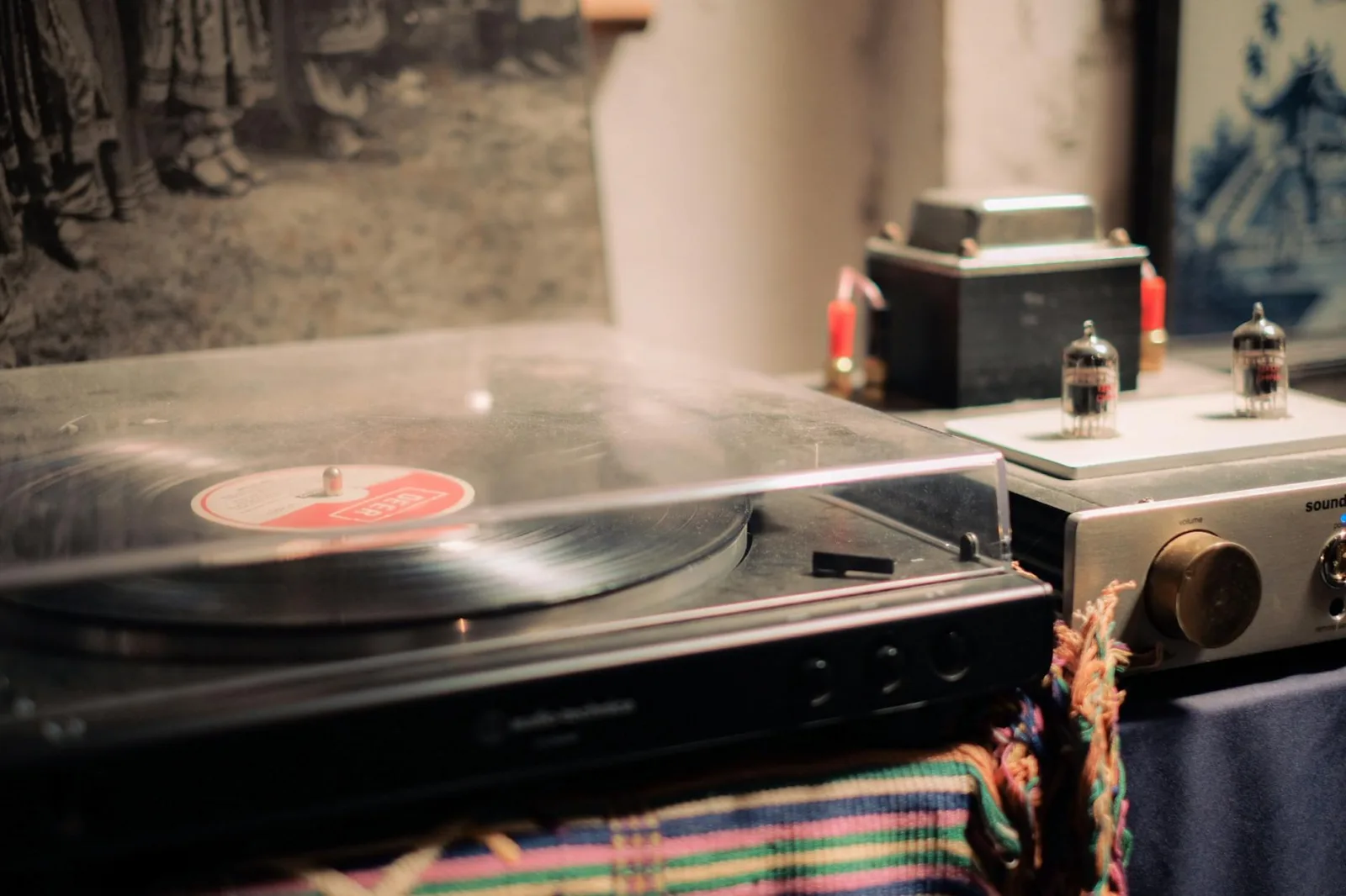 A cozy, vintage record player setup with an amplifier, tubes, and a nostalgic vibe.