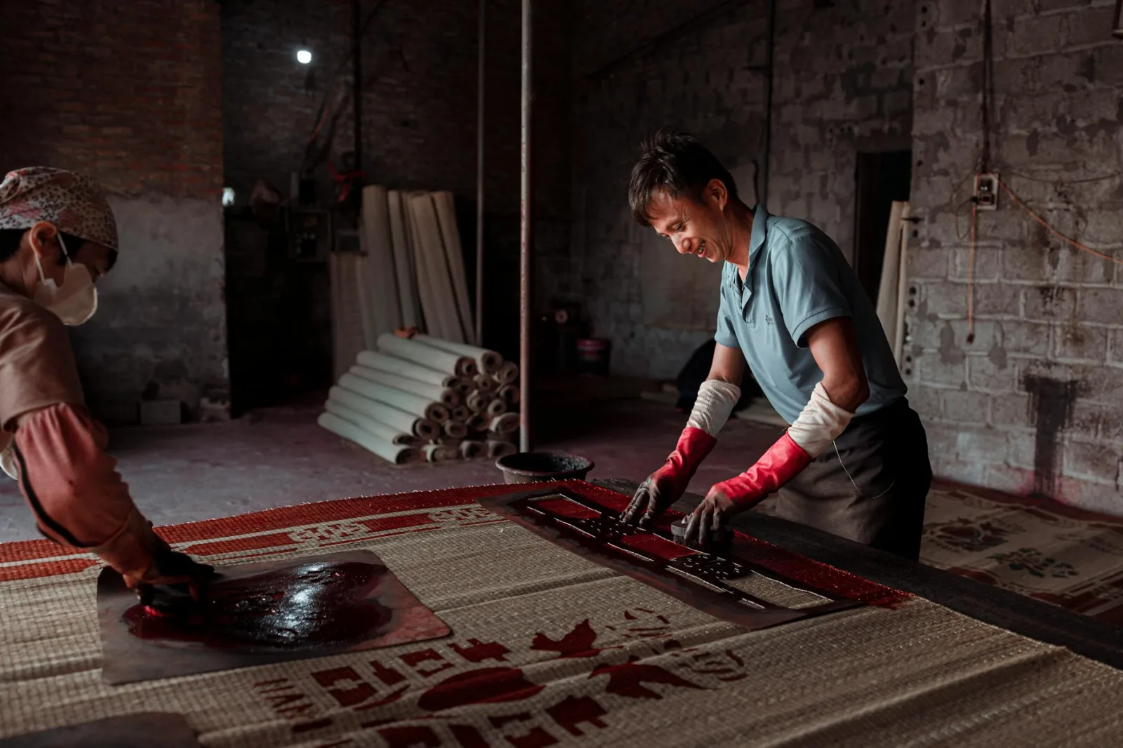Two artisans working on traditional crafts indoors with precision and care.