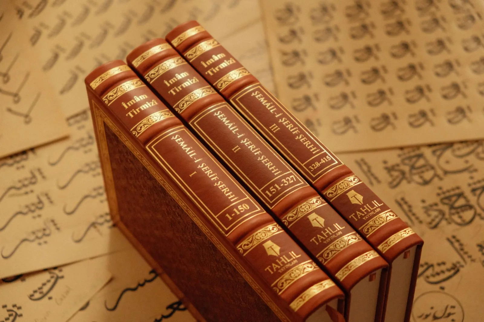Leather-bound Islamic books with ornate text in an elegant setting.
