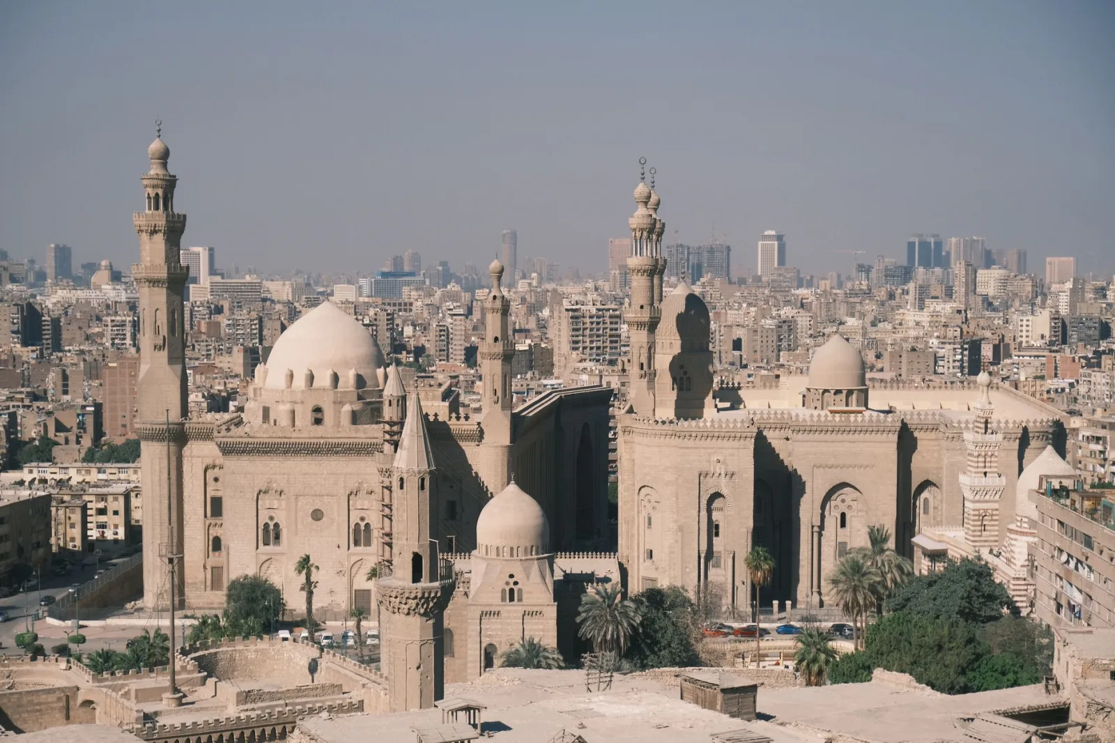 Scenic aerial view of Cairo with the iconic Mosque-Madrassa of Sultan Hassan and city skyline.