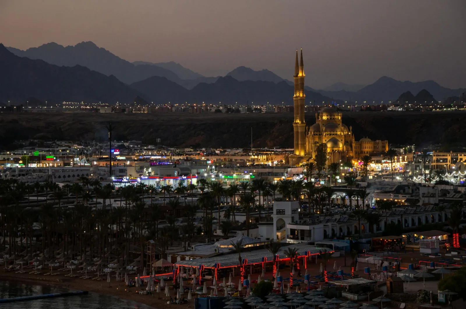 Nighttime scene of an illuminated mosque and cityscape in Sharm El Sheikh, Egypt.