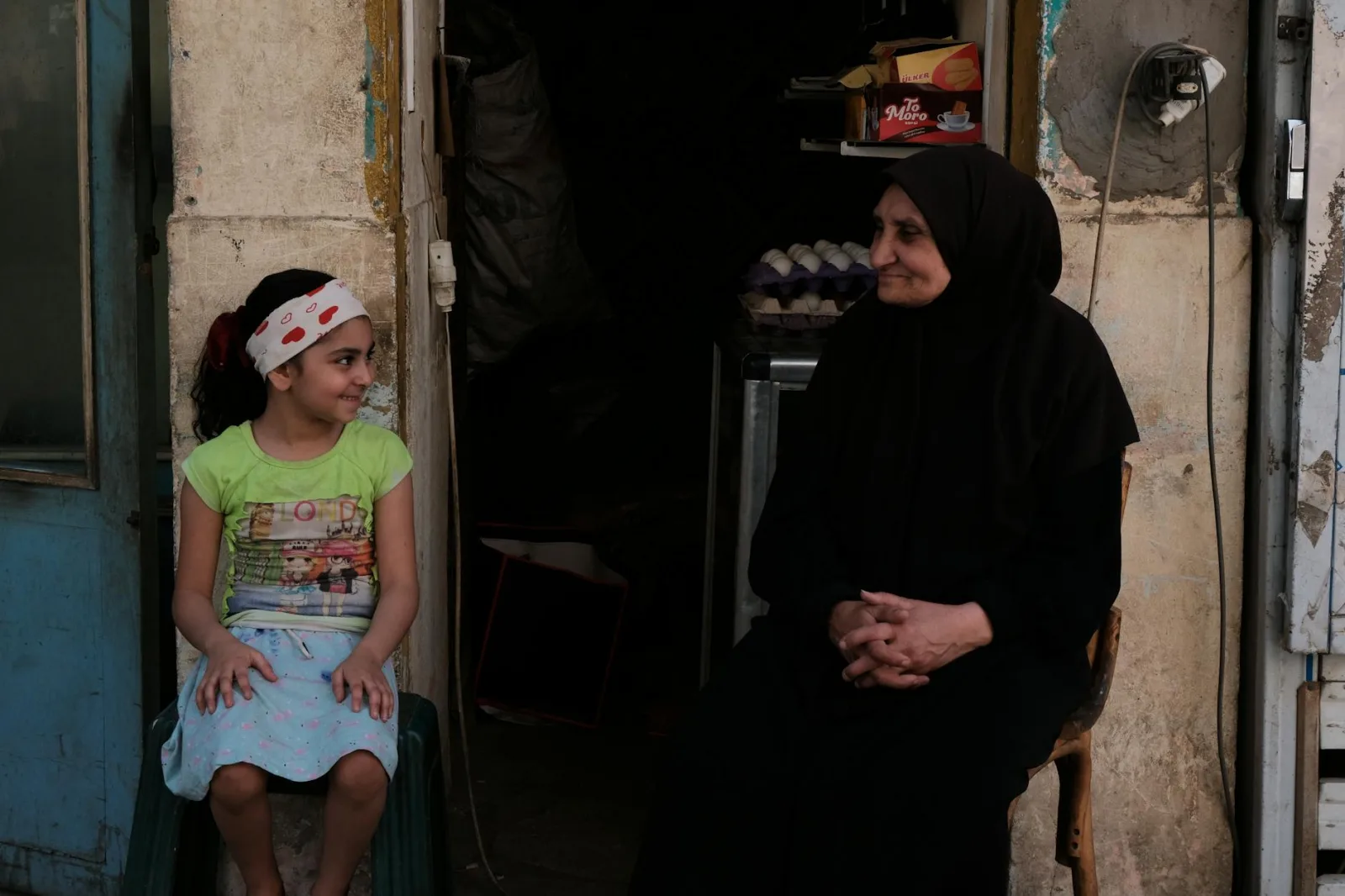 Heartwarming interaction between a child and elderly woman on a street in Cairo, Egypt.
