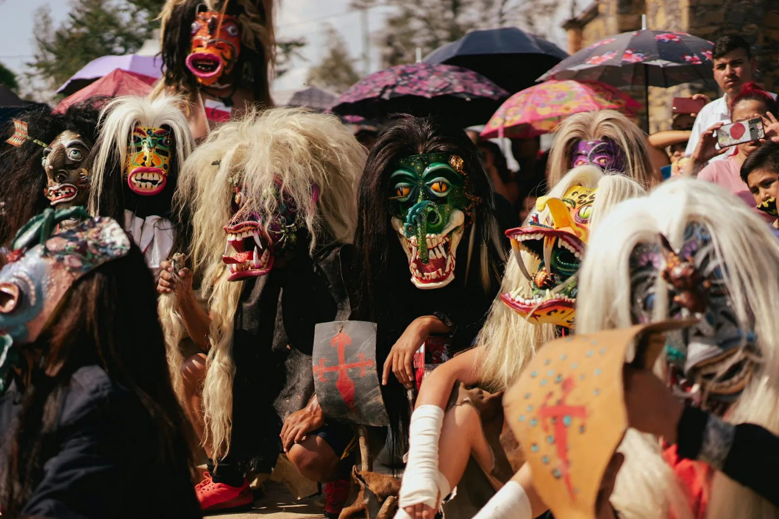 Colorful masked participants at a traditional Mexican festival outdoors.