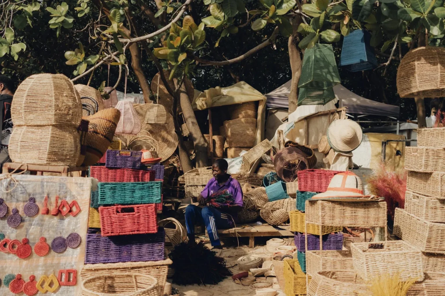 Colorful handmade baskets and crafts displayed at an outdoor Nigerian market.