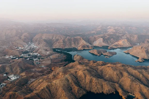 Stunning aerial shot of Oman mountains with lake views, showcasing serene natural beauty.