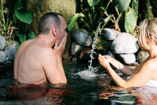 A couple leisurely enjoying a natural hot spring in an outdoor setting