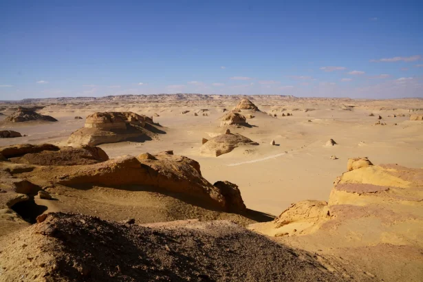A breathtaking view of the Egyptian desert with unique rock formations under a bright clear sky.
