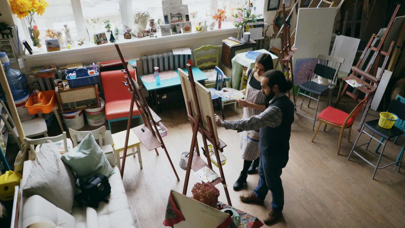 Adults painting in a vibrant art studio, engaged in a creative class.