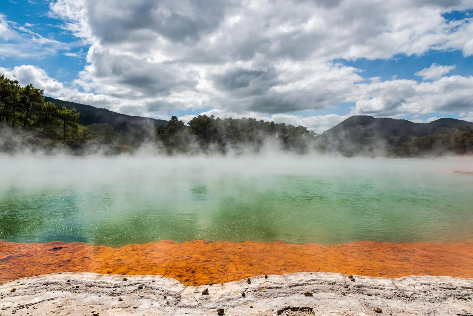 Natural hot spring with colorful minerals and vapor in New Zealand.