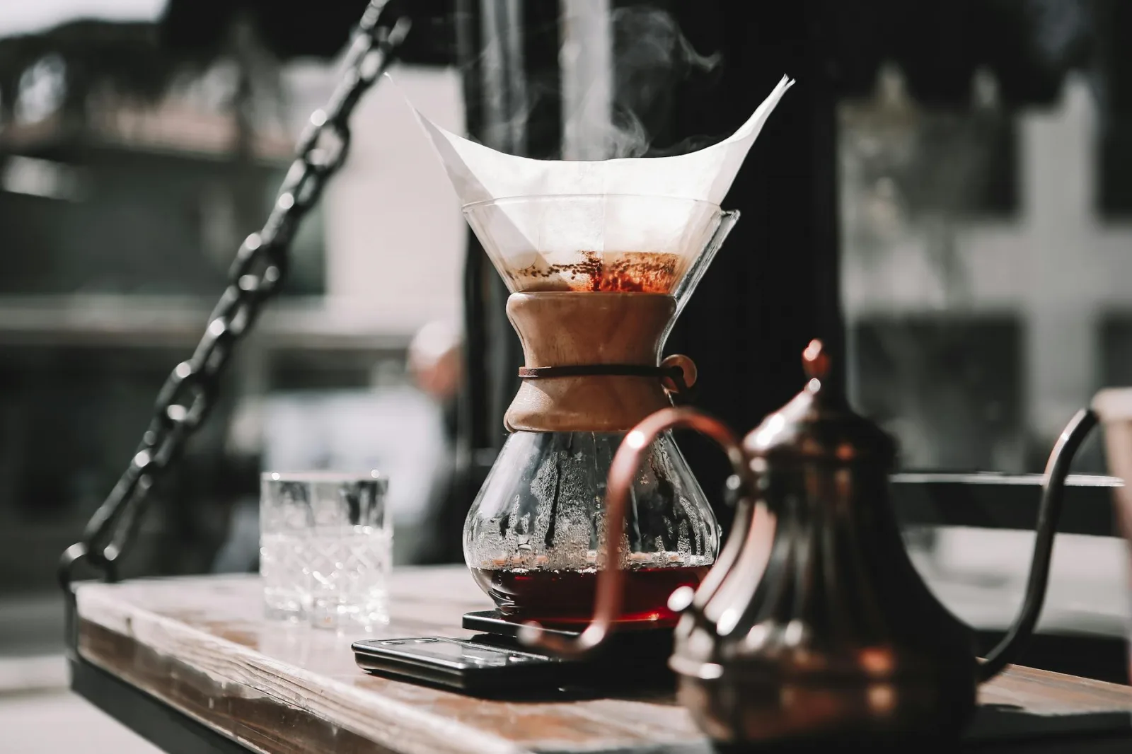 Artistic shot of steaming coffee pour over method in a cozy cafe setting, perfect for coffee enthusiasts.