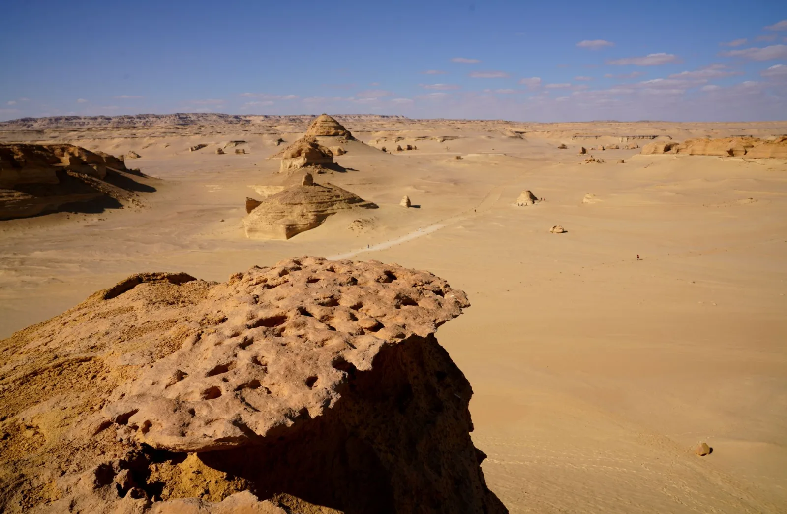 Expansive desert landscape in Egypt with unique rock formations and clear blue sky.