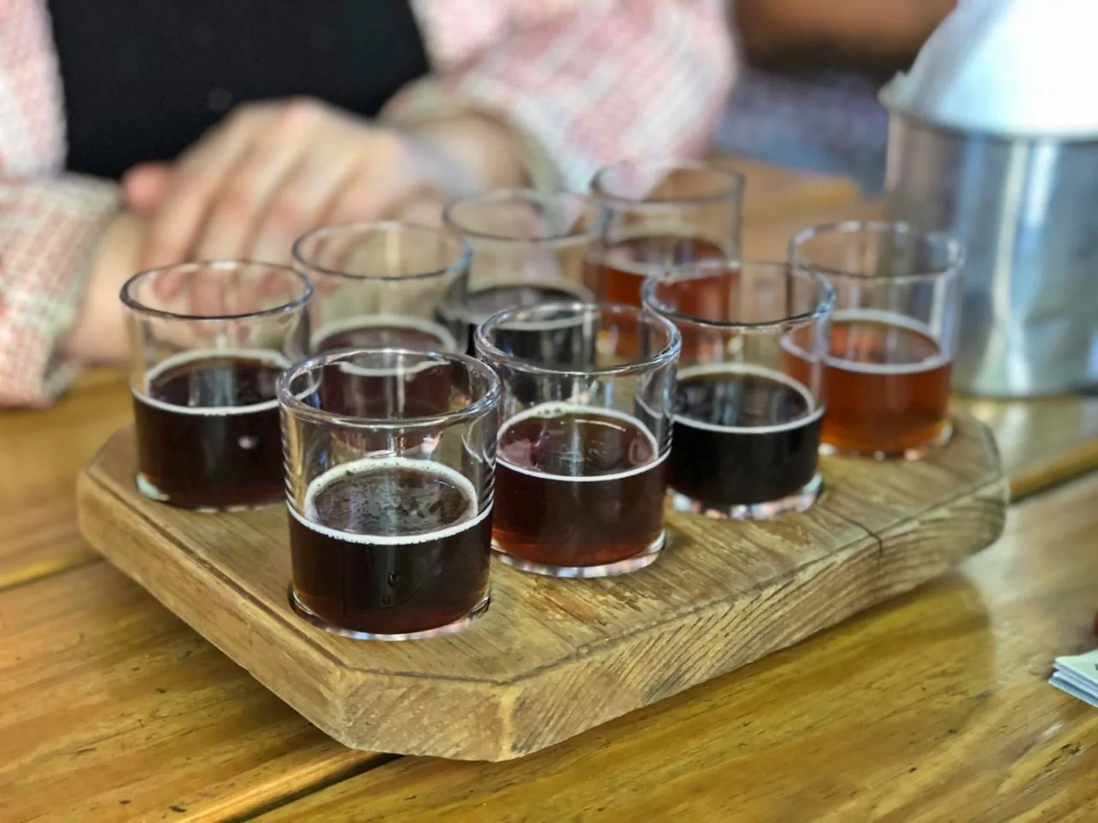 Sample a variety of craft beers served on a wooden tray, perfect for tasting experience.