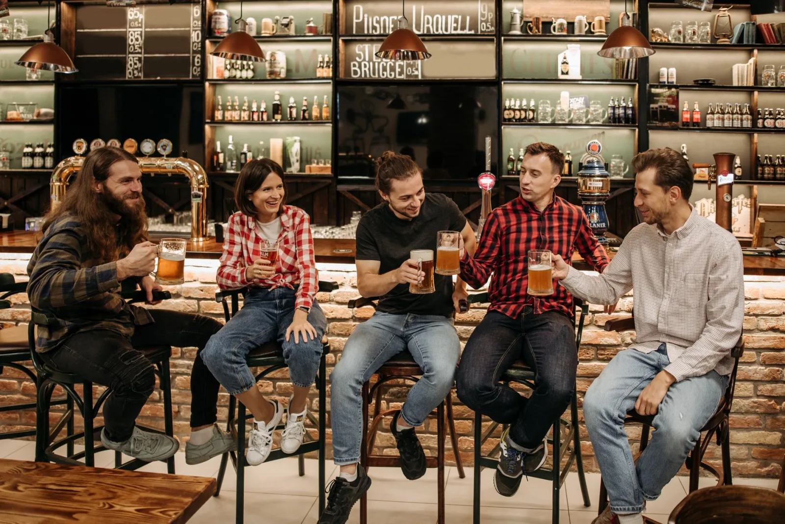 A group of friends having fun and enjoying beers together in a cozy pub setting.