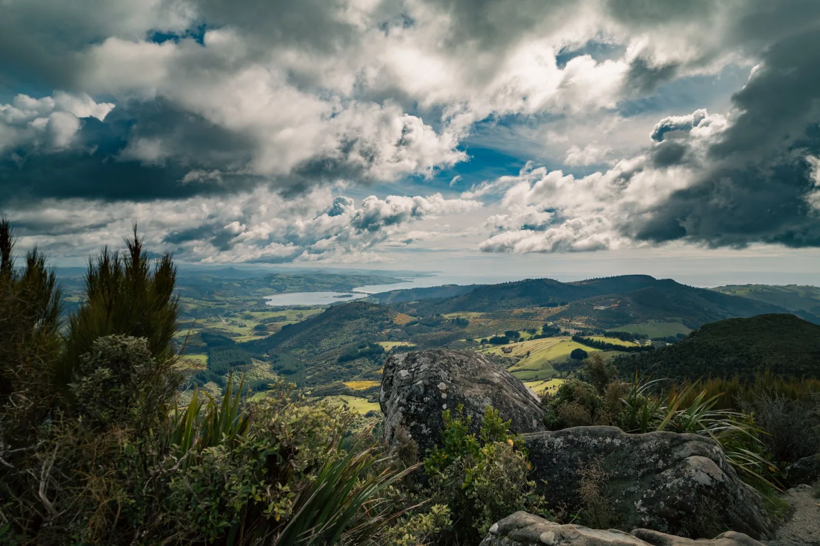 Stunning New Zealand landscape with mountains and dramatic clouds under a vibrant sky.