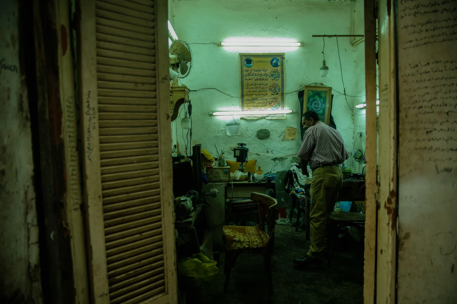Atmospheric interior of an old shop in Cairo with a local man, vintage furnishings, and vibrant signage.