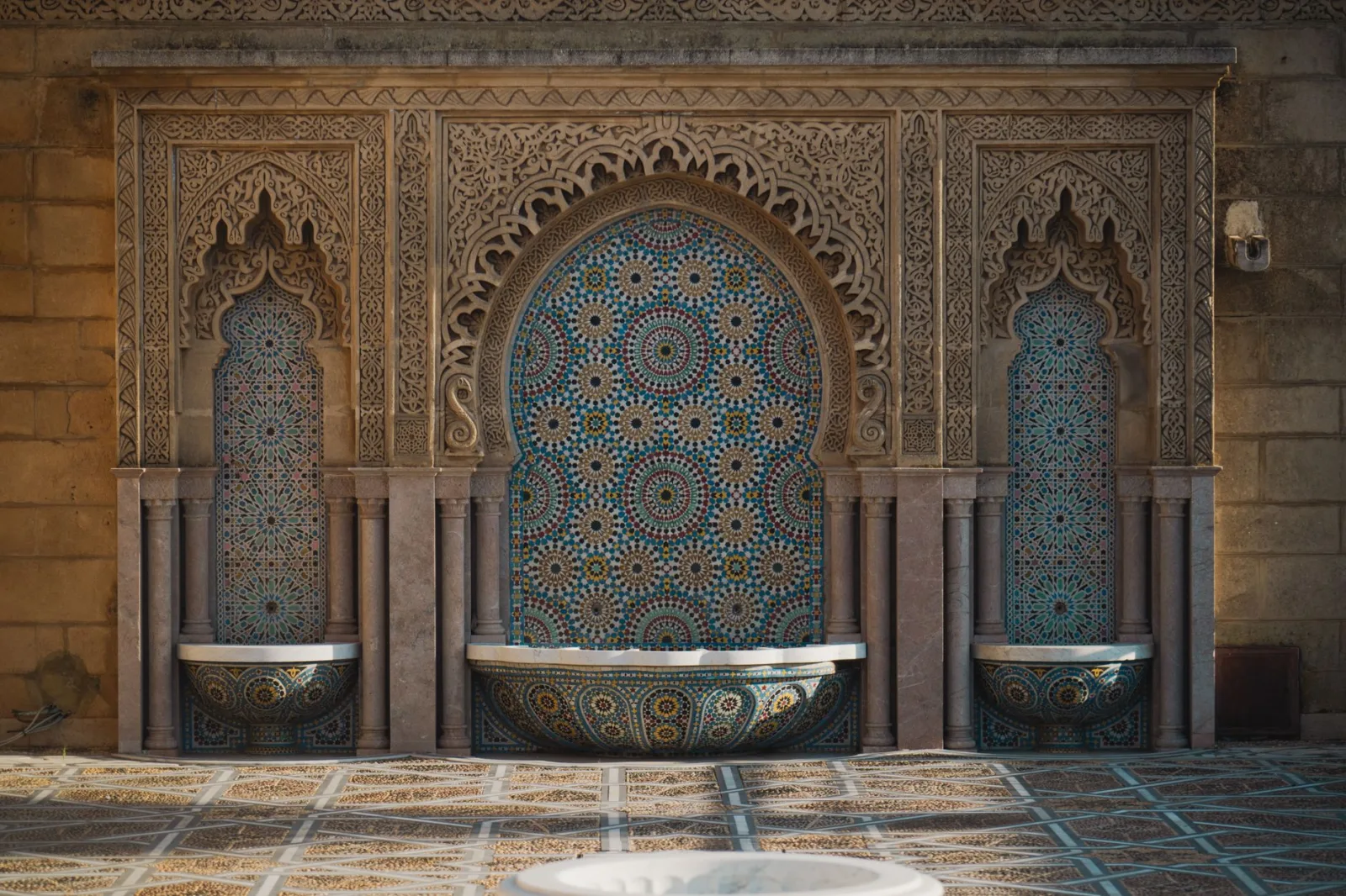 Traditional Moroccan architecture featuring a detailed mosaic water fountain with intricate designs.
