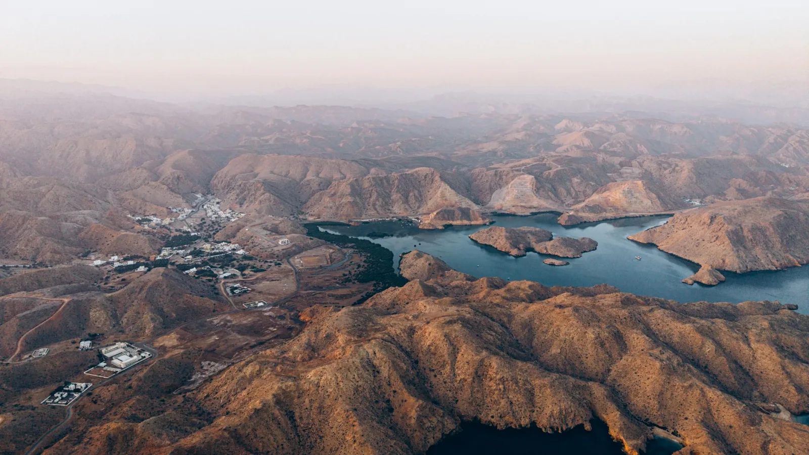 Stunning aerial shot of Oman mountains with lake views, showcasing serene natural beauty.