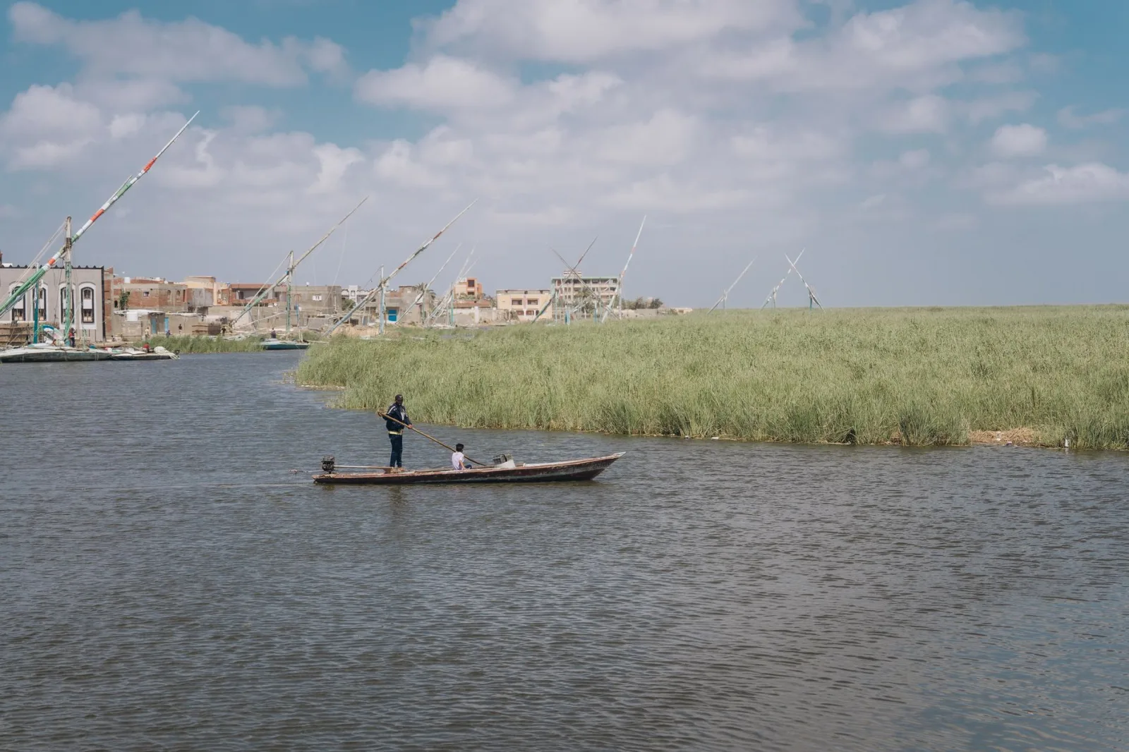 Scenic view of fishermen on a boat in Kafr El-Shaikh, Egypt under a clear sky.