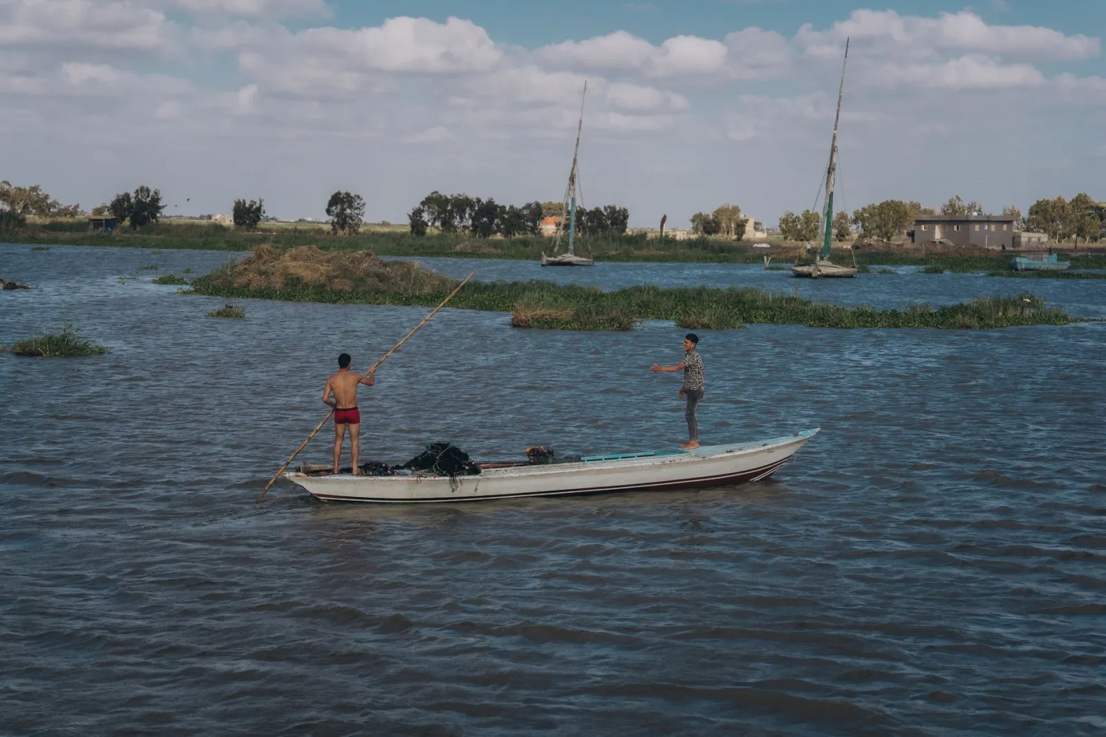 Two fishermen engage in traditional fishing on the Nile River, capturing authentic Egyptian culture.