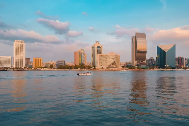 Stunning view of Dubai's skyline and Dubai Creek at sunset with reflecting skyscrapers.