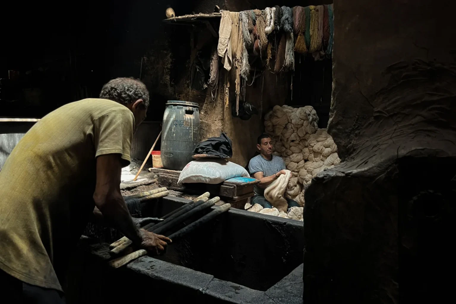 Authentic scene of two men working in a textile dyeing workshop in Cairo, Egypt.