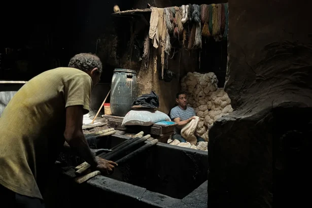 Authentic scene of two men working in a textile dyeing workshop in Cairo, Egypt.