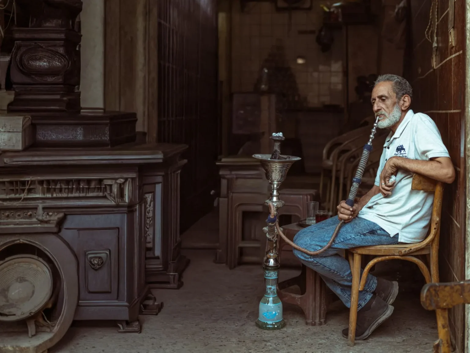 Elderly man smoking hookah in a traditional Cairo setting, capturing a moment of relaxation and culture.