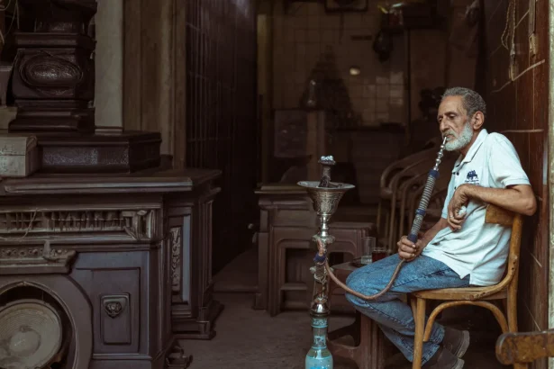 Elderly man smoking hookah in a traditional Cairo setting, capturing a moment of relaxation and culture.