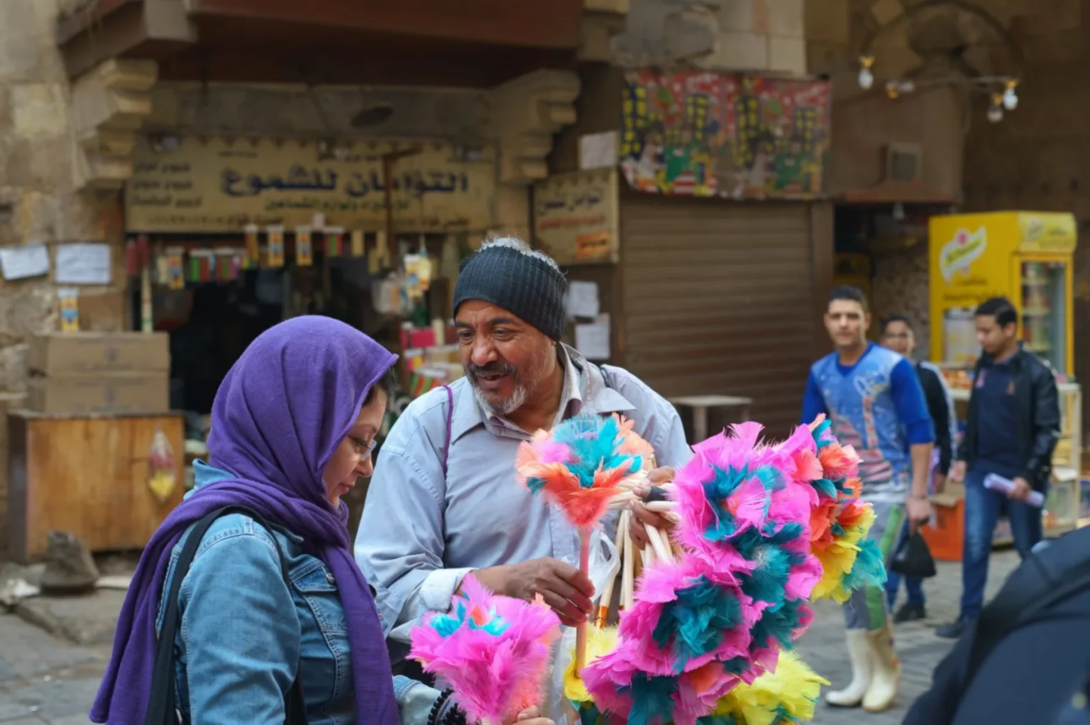People interacting at a lively market in Cairo, displaying cultural diversity and vibrant street life.