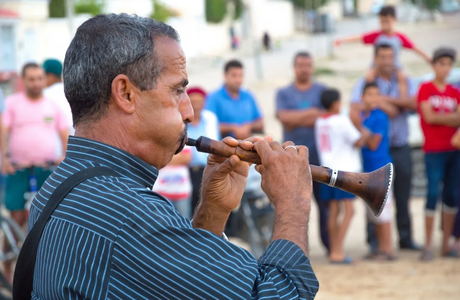 A street musician playing the traditional zukra in a vibrant Tunisian setting.