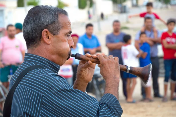 A street musician playing the traditional zukra in a vibrant Tunisian setting.