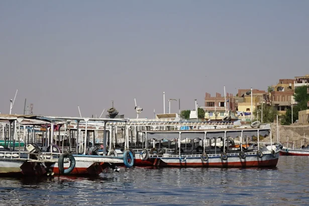 Colorful boats docked along the Nile River in Egypt under a clear blue sky.