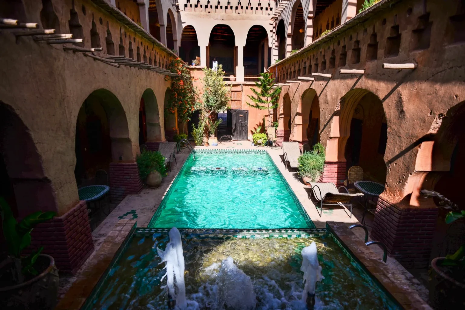 Beautiful courtyard with a central pool and historic architectural elements under daylight.