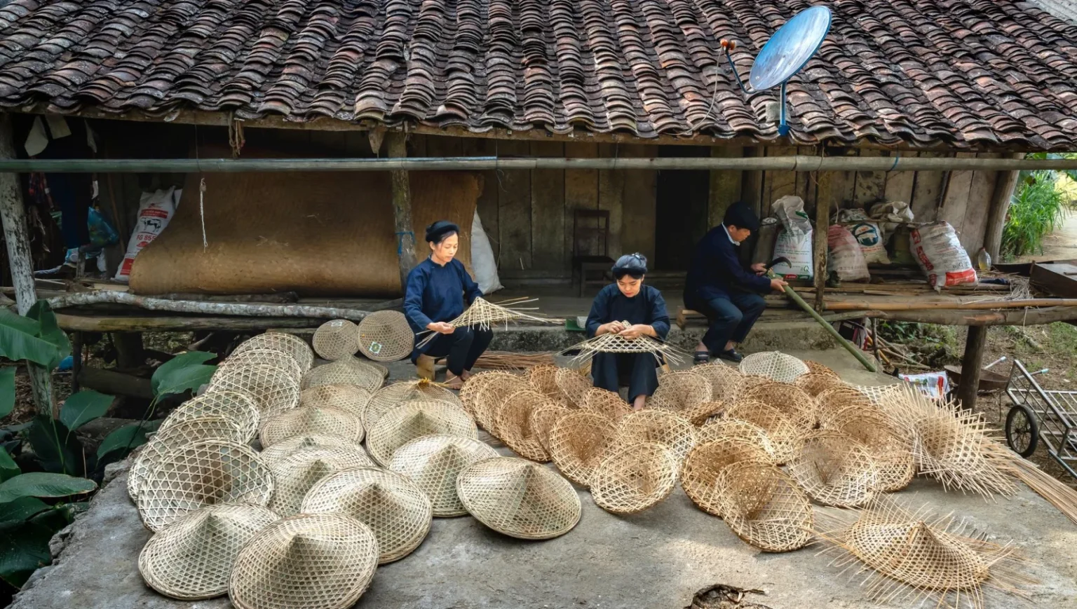 Artisans skillfully weave baskets in a rural village, showcasing traditional craftsmanship.