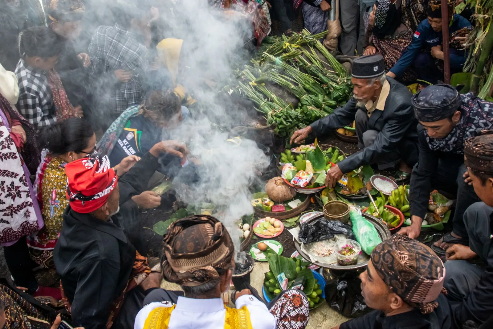 A vibrant cultural gathering with traditional ritual and offerings, rich with diverse attire and greenery.