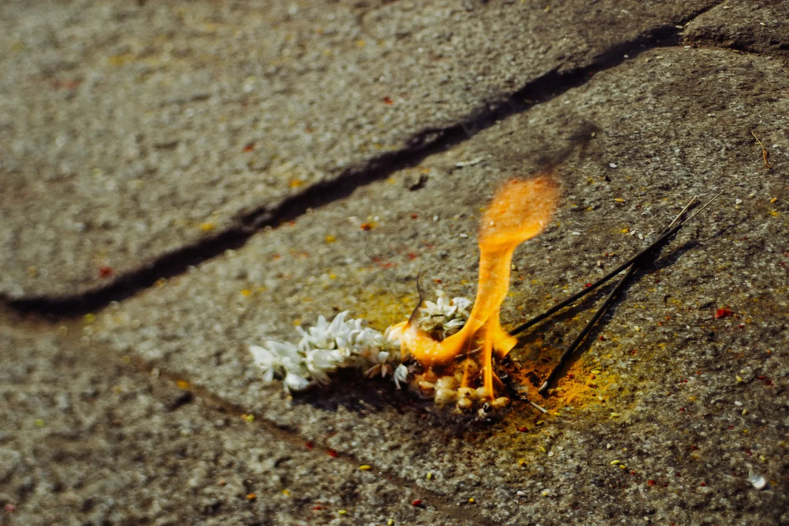Oriental aroma religious incense sticks burning on shabby stone ground in Asian country