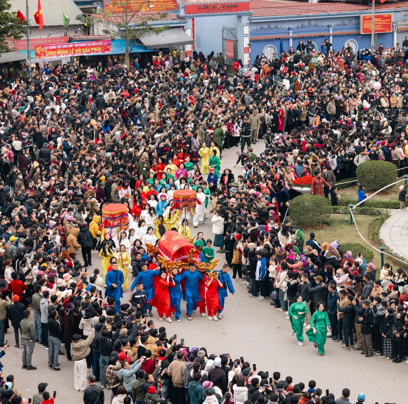 A colorful procession at the Ky Cung Ta Phu Temple Festival in Lạng Sơn, Vietnam, attracting a large crowd.