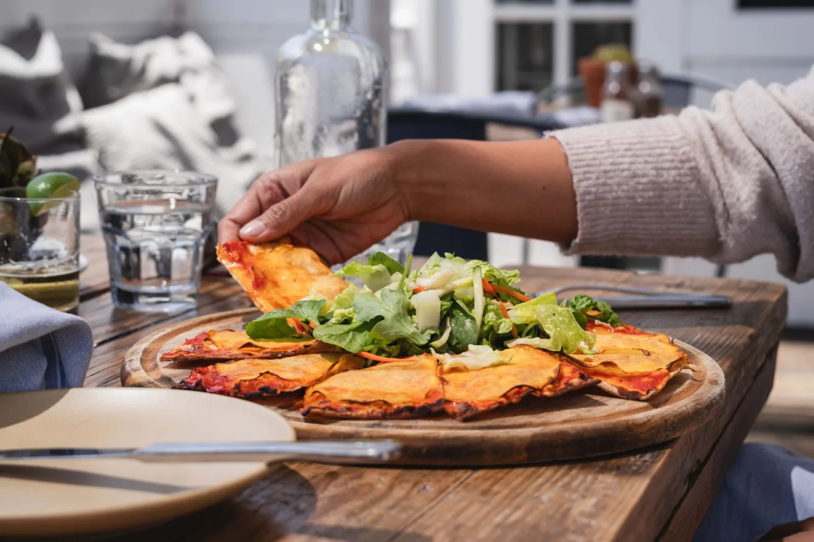 Enjoy a delicious gourmet pizza with fresh salad outdoors in Malibu, California.