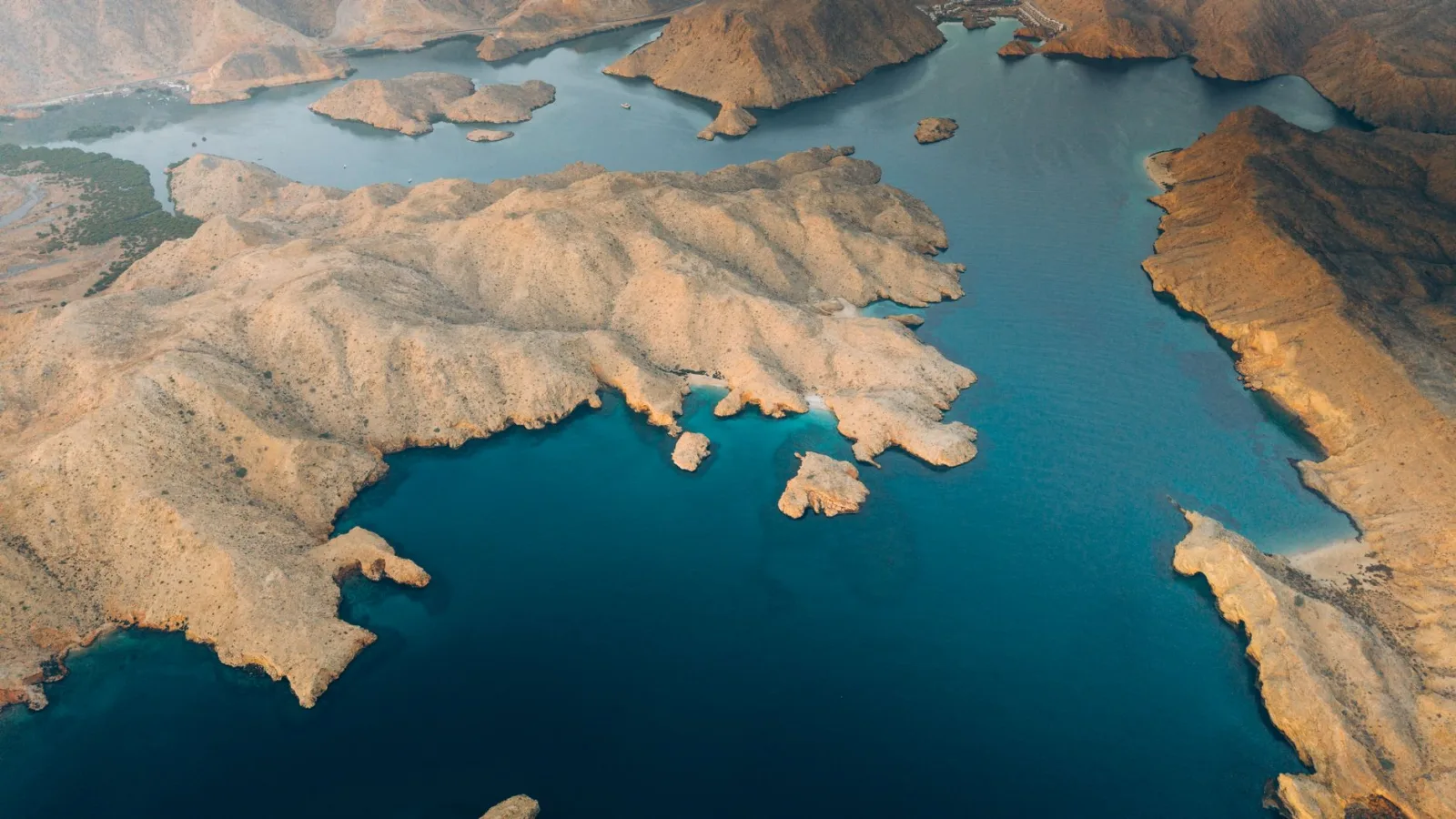 Explore Oman’s breathtaking coastal landscapes from above, capturing rugged cliffs meeting azure seas.
