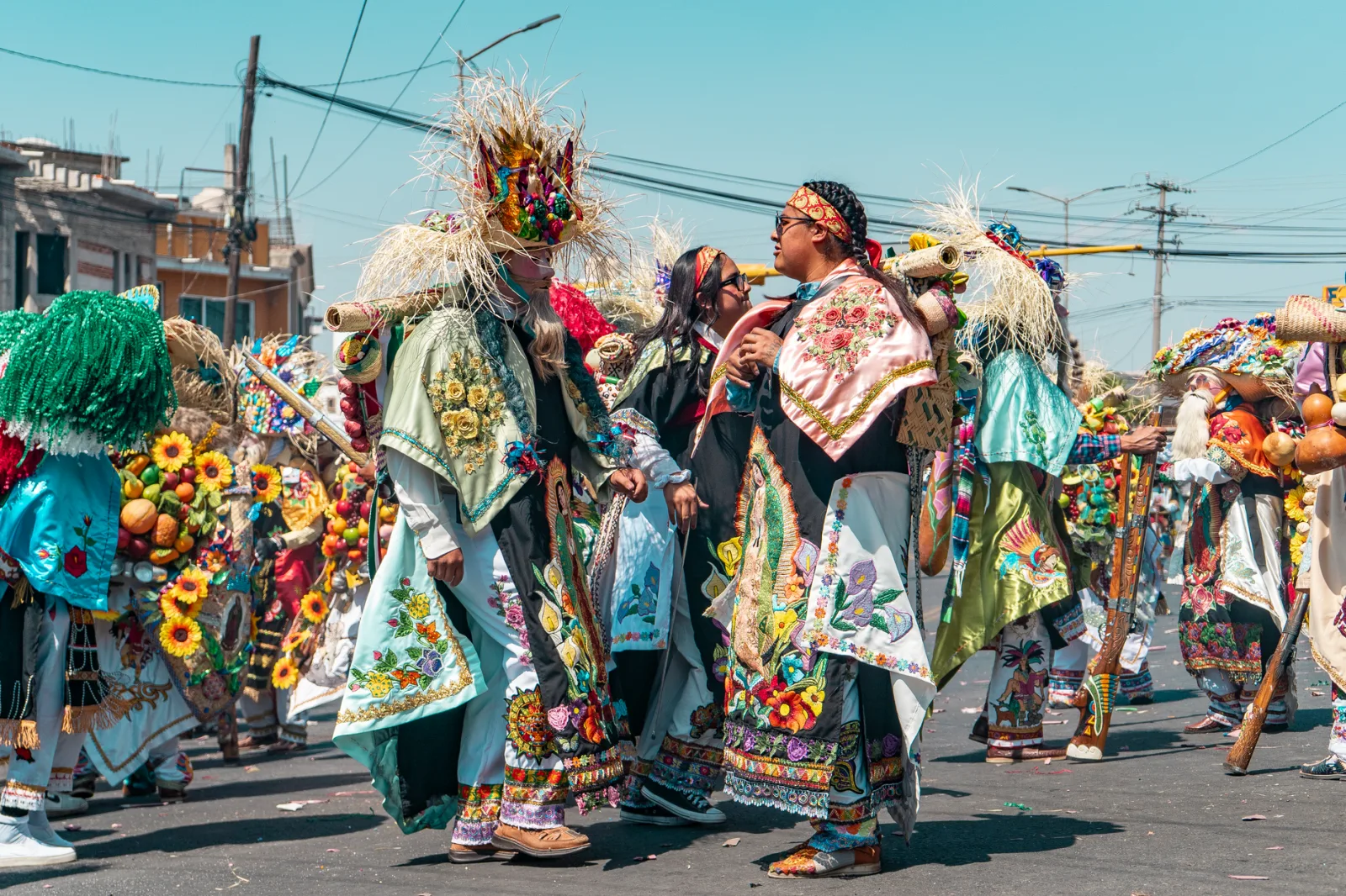 Colorful traditional street festival with people in elaborate costumes celebrating outdoors.