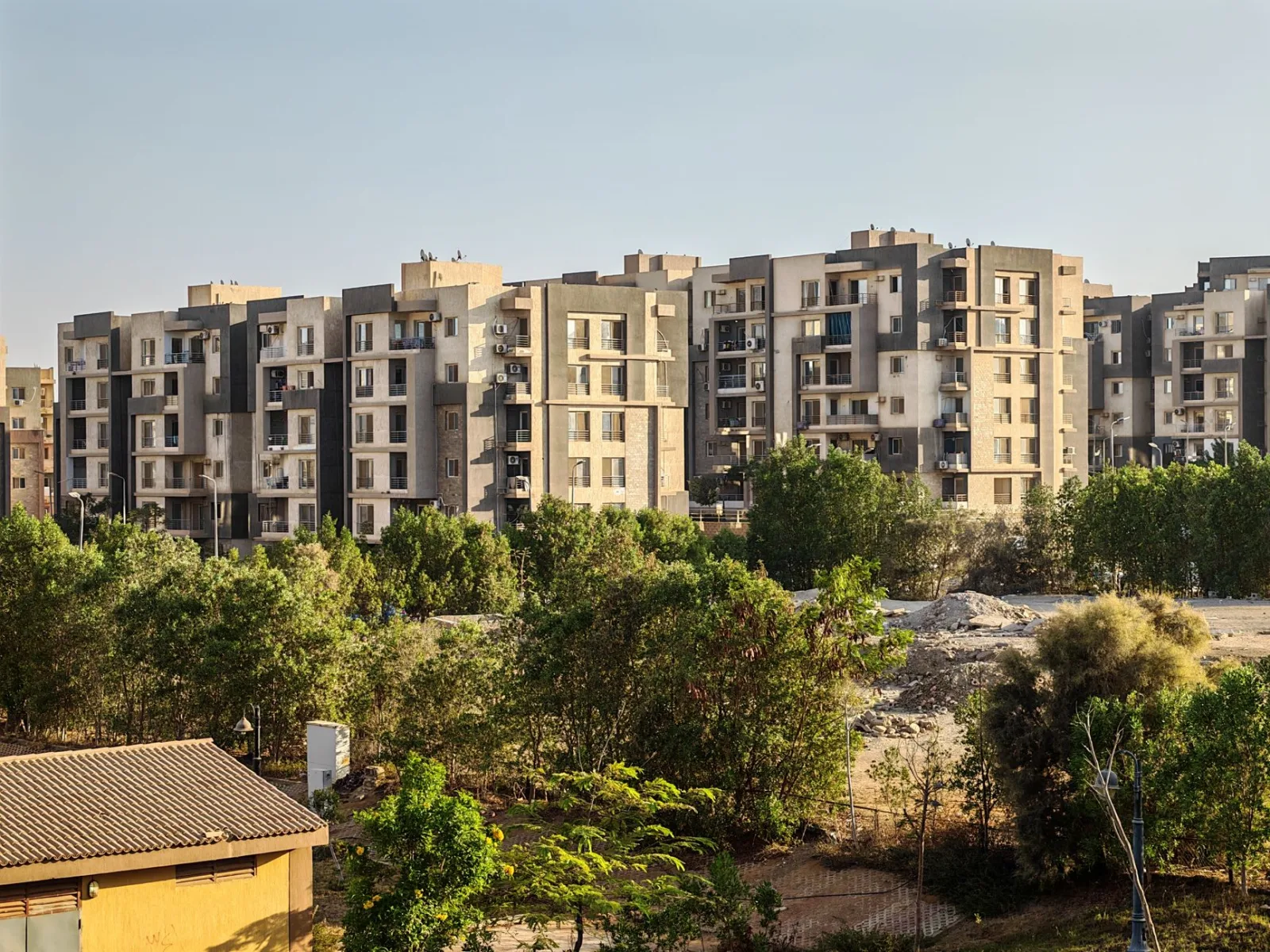 Contemporary apartment complex with lush greenery in urban setting.