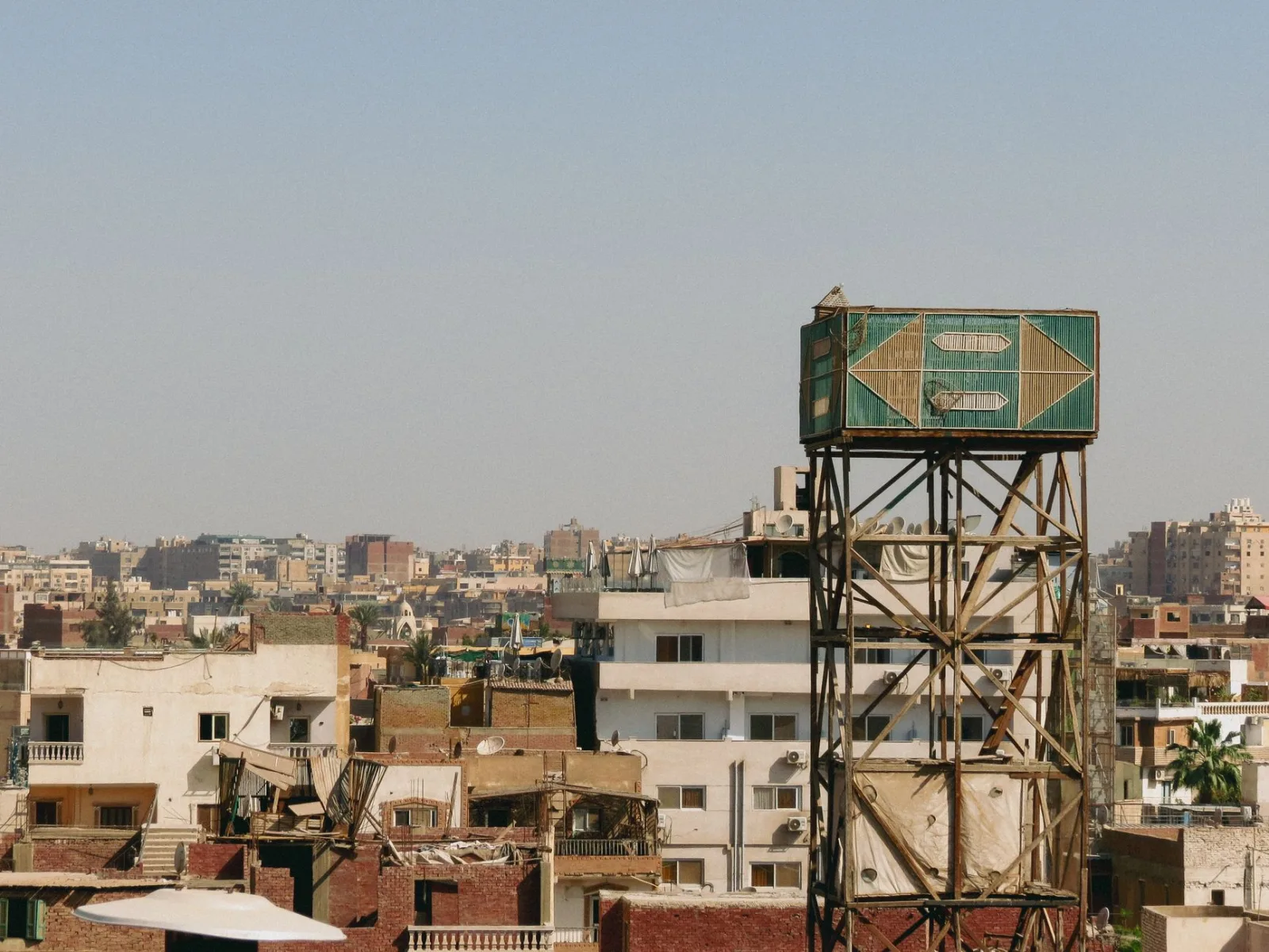 View of urban rooftops and water tower in Cairo cityscape.