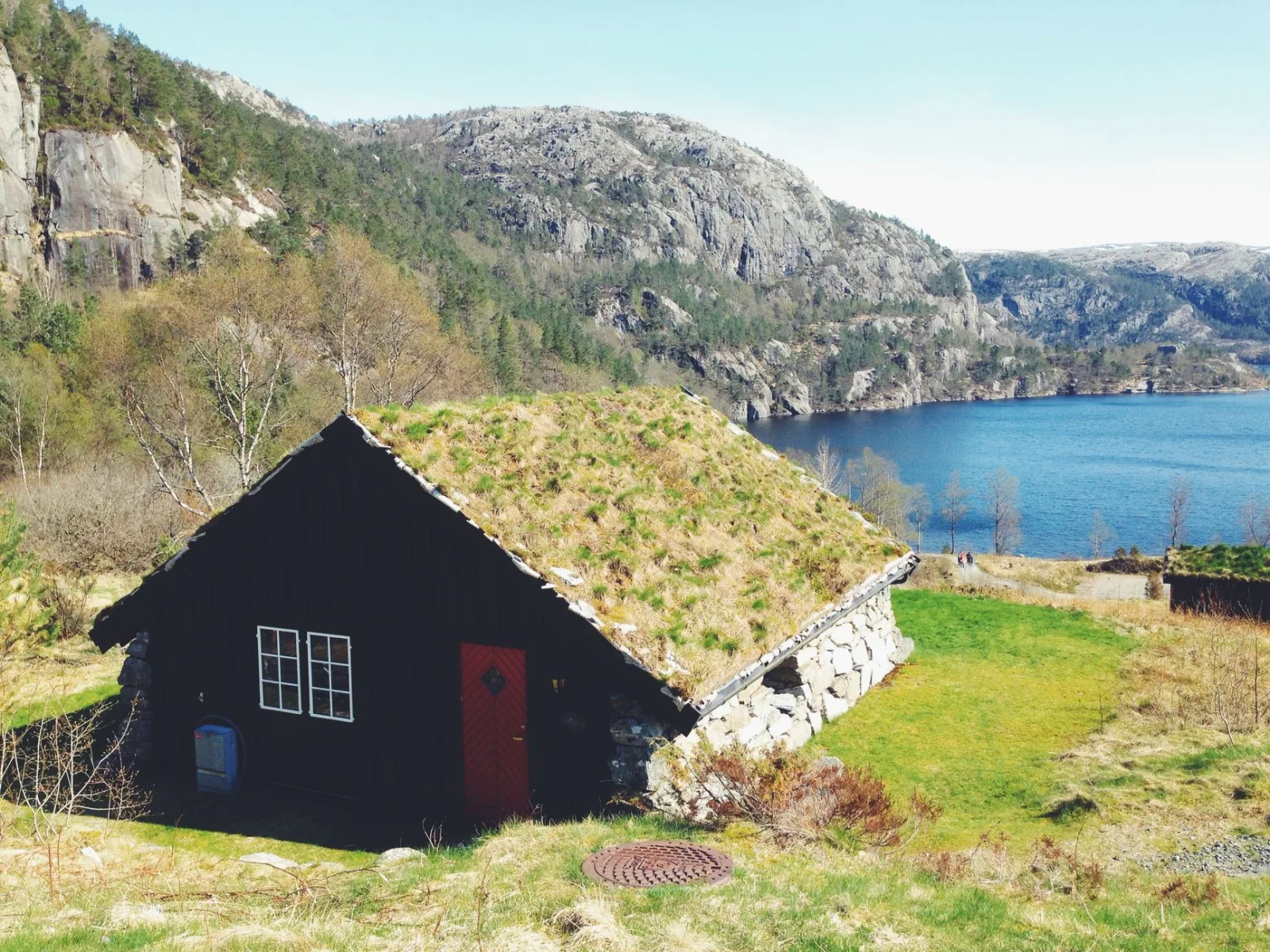 Quaint lakeside cabin amidst scenic mountains and greenery, perfect for serene retreats.