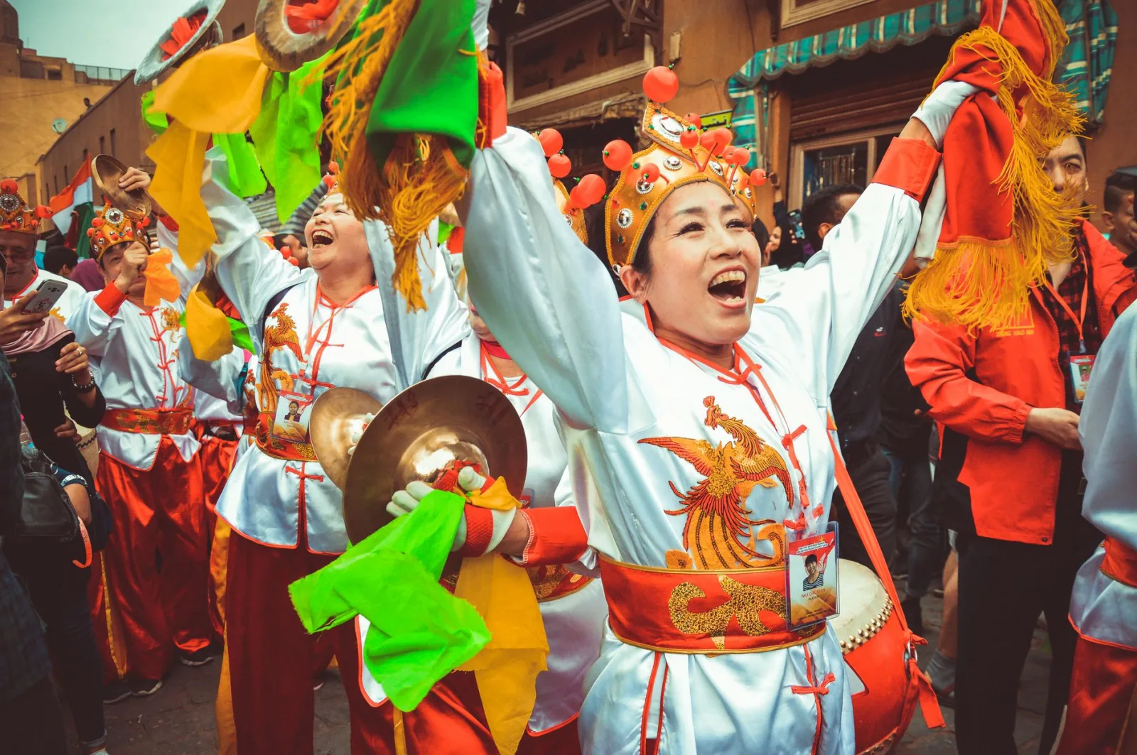 Joyous performers in traditional attire at Cairo's colorful drum festival celebration.