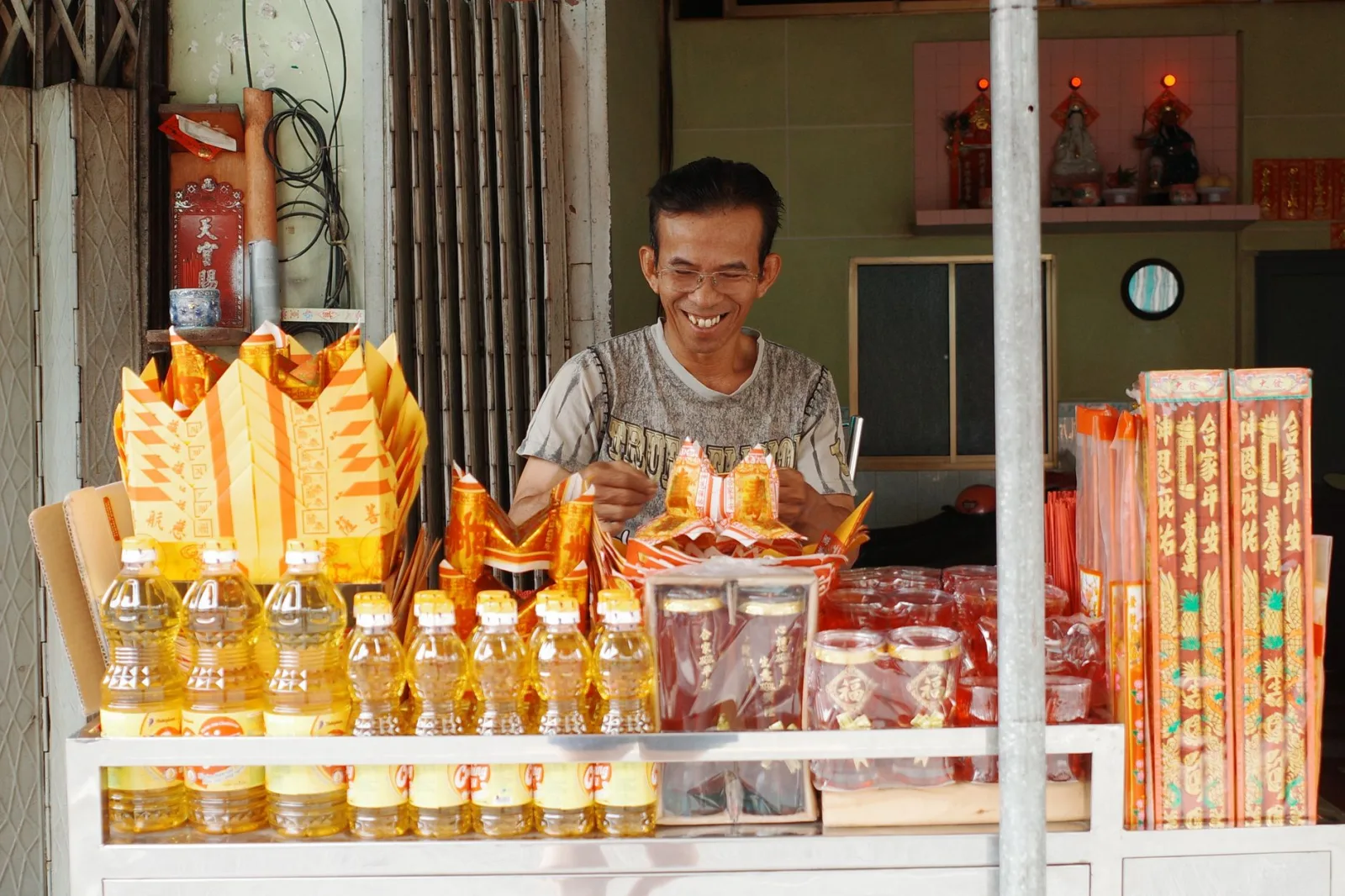 A cheerful vendor preparing offerings at a market stall in Ho Chi Minh City, Vietnam.
