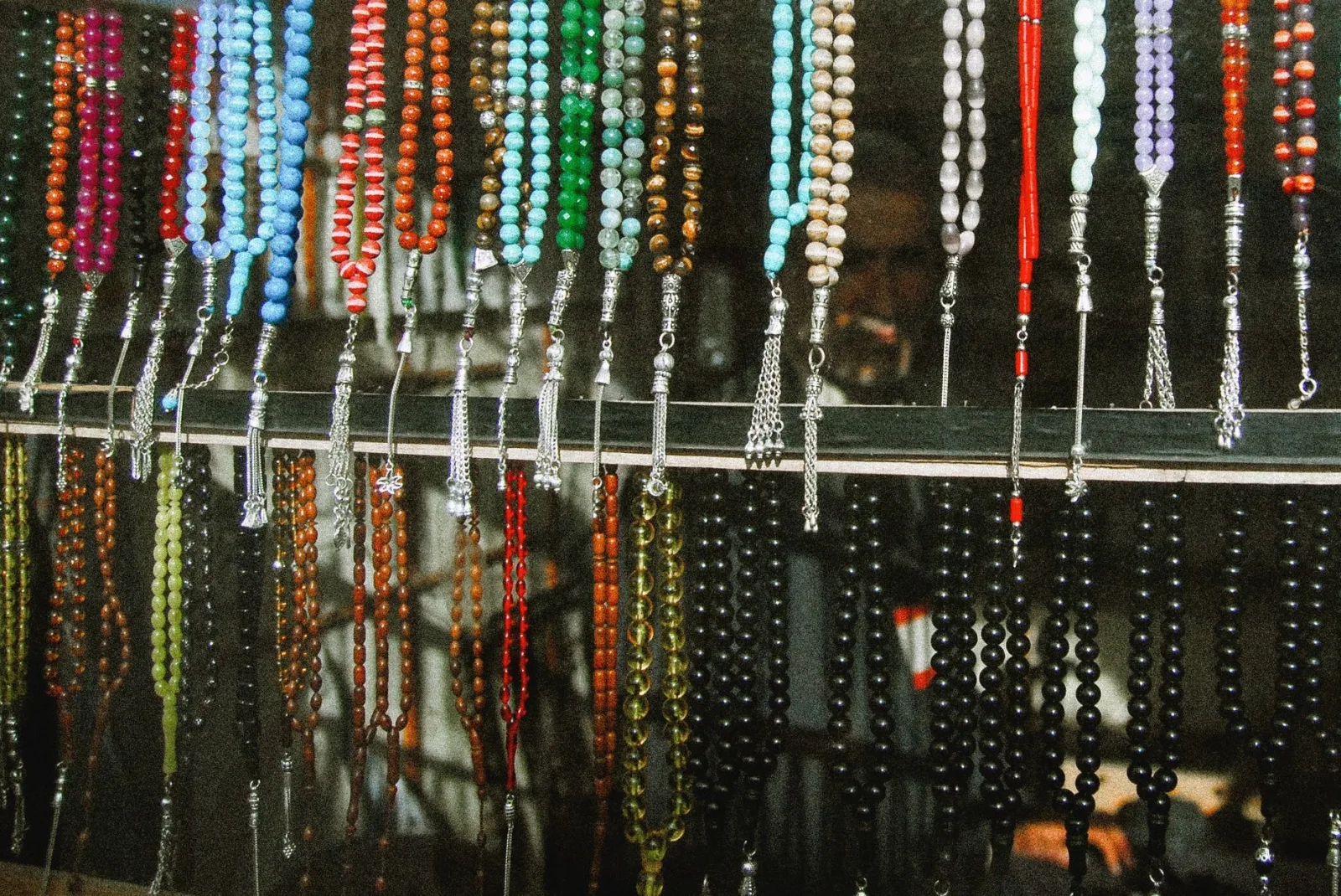 Vibrant assortment of prayer beads beautifully displayed in a traditional marketplace setting.